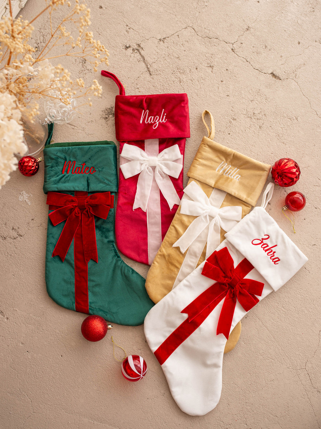 All Wrapped Up personalised Christmas stocking, all four colours laid flat together, green, red, gold and white, each with a name on the cuff - Before & Ever Kids