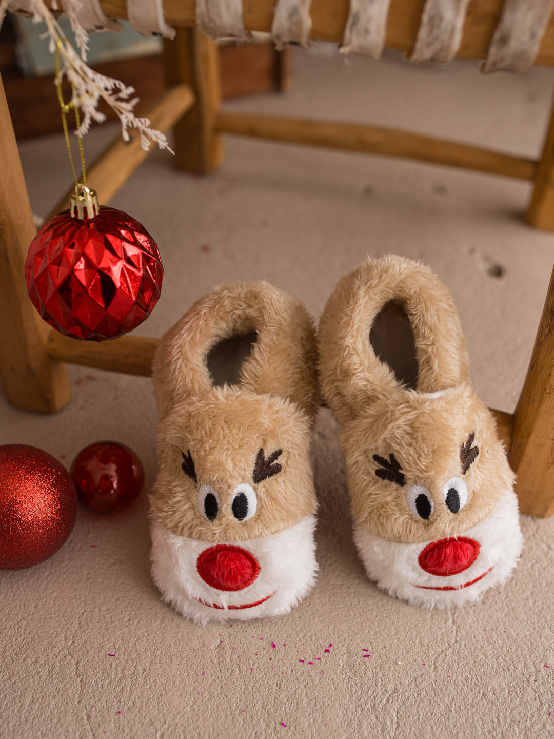 Baby Rudolph Slippers tan fluffy reindeer slippers by a wooden chair - Before & Ever Kids