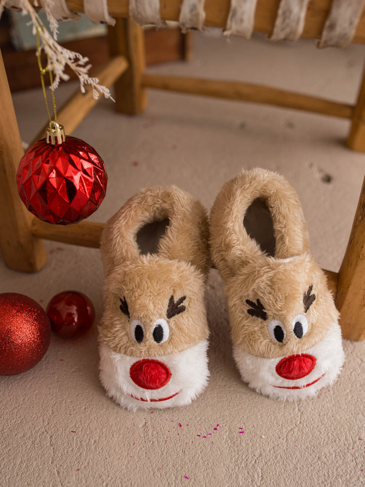 Baby Rudolph Slippers tan fluffy reindeer slippers by a wooden chair - Before & Ever Kids
