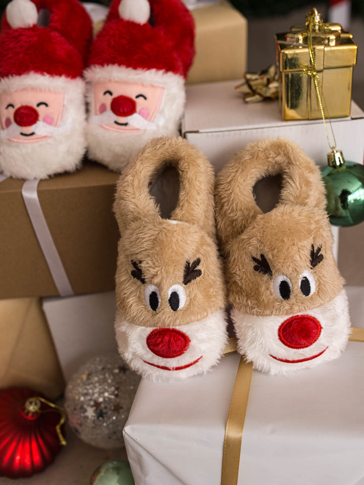 Baby Rudolph Slippers and Santa Baby Slippers on gift boxes by the tree - Before & Ever Kids