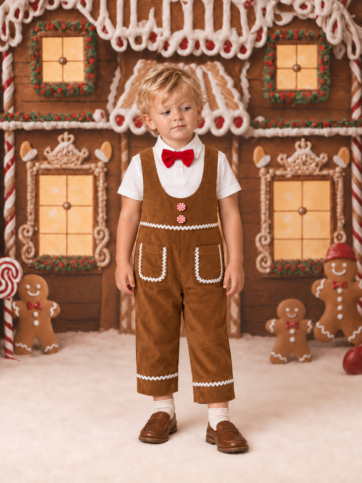 Catch Me If You Can caramel velvet boy overall worn by a toddler with a white shirt and red bow tie, full length in front of a gingerbread house - Before & Ever Kids