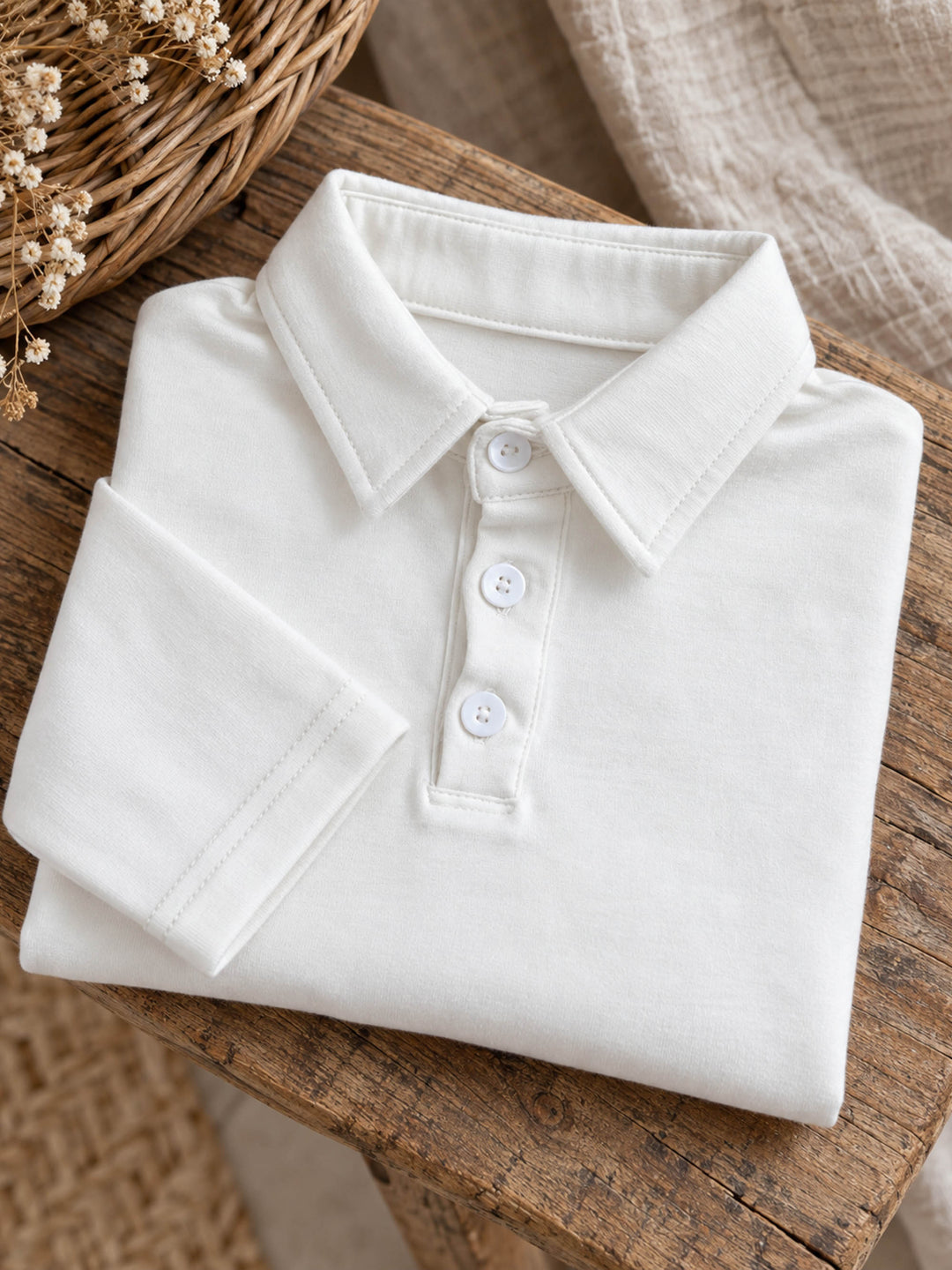 Everyday Cotton Polo, white long sleeve cotton polo, folded on a wooden stool - Before & Ever Kids