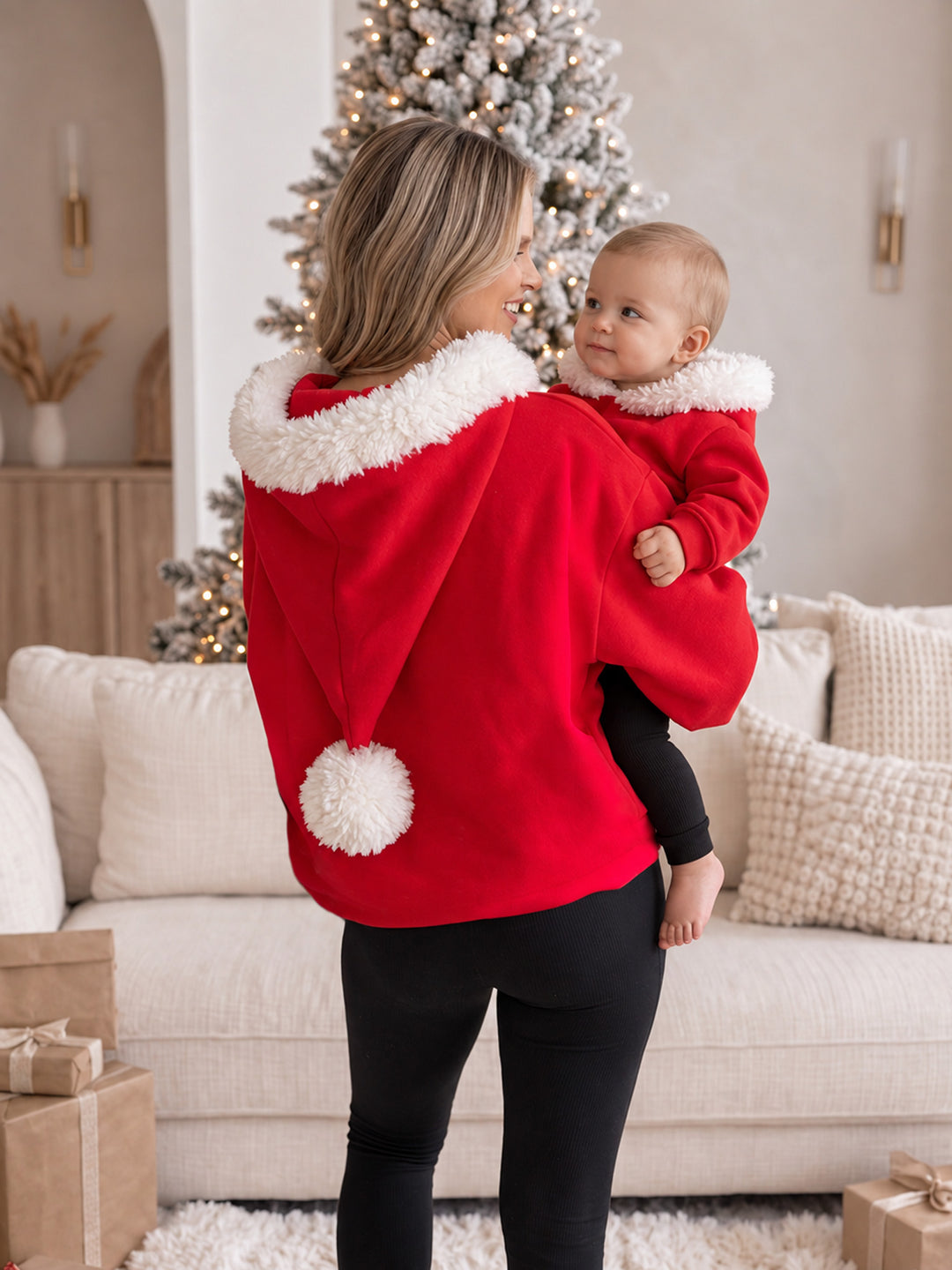 Ho Ho Hoodie red kids hoodie on a baby being carried, back view, with the matching adult hoodie - Before & Ever Kids