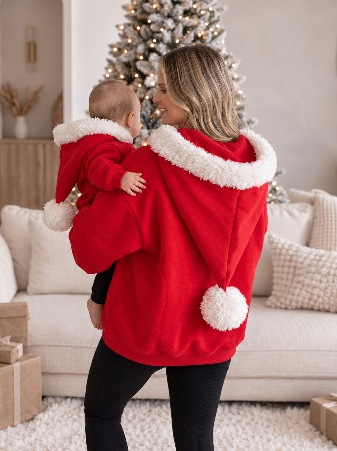 Ho Ho Hoodie red adult hoodie from behind showing the pom-pom on the Santa hat hood, a mum carrying a baby - Before & Ever Kids