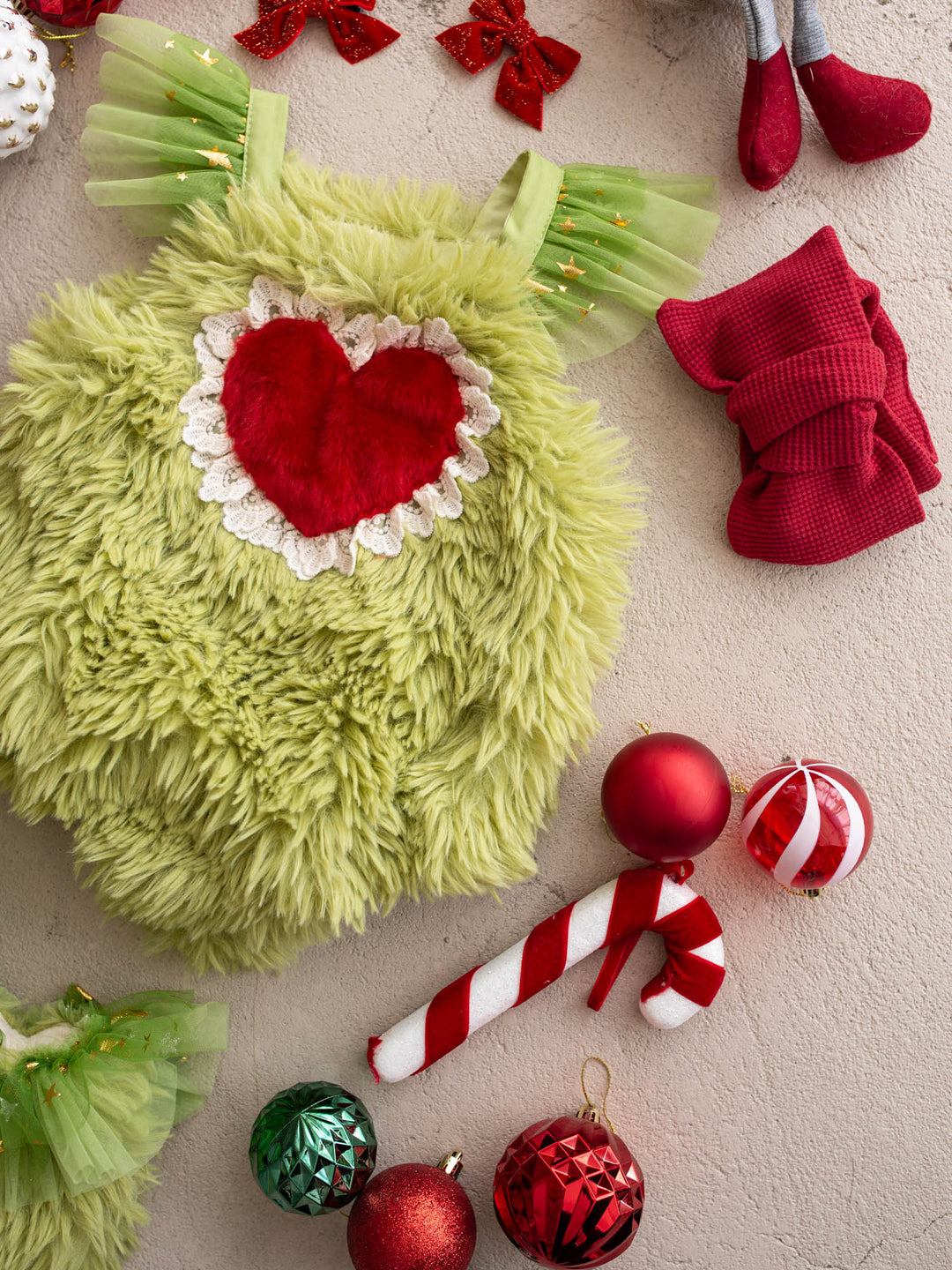 Little Grump green faux-fur Christmas romper with a red fur heart, red waffle leg warmers and a candy cane - Before & Ever Kids