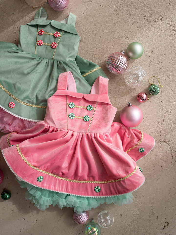 Merry Berry pink and mint close flat lay beside the sage green Merry Mint dress, pink velvet pinafore with mint peppermint buttons, gold braid and pom pom trim - Before & Ever Kids