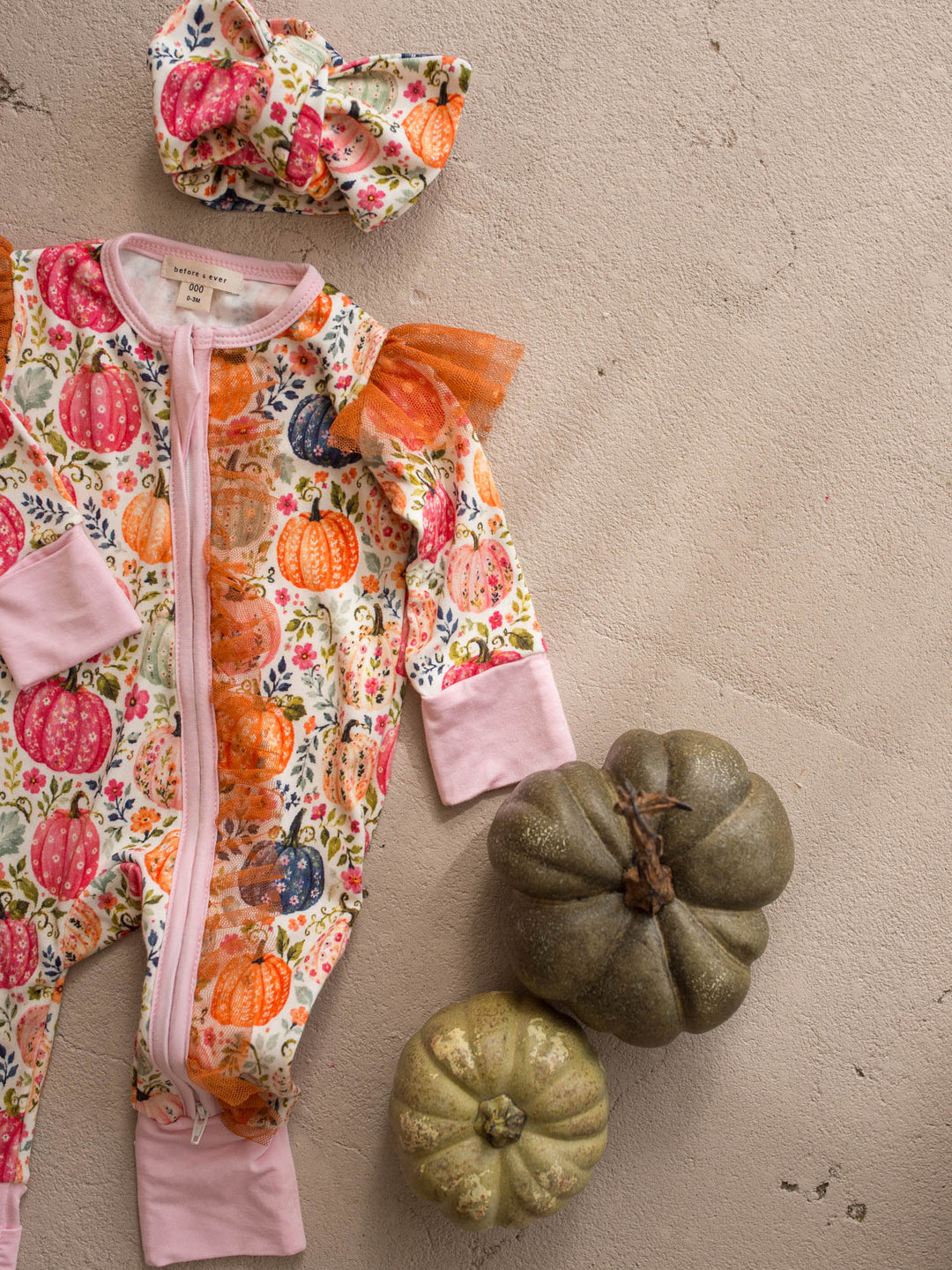 Patch Perfect pink pumpkin bamboo baby girl onesie flat lay with topknot - Before & Ever Kids
