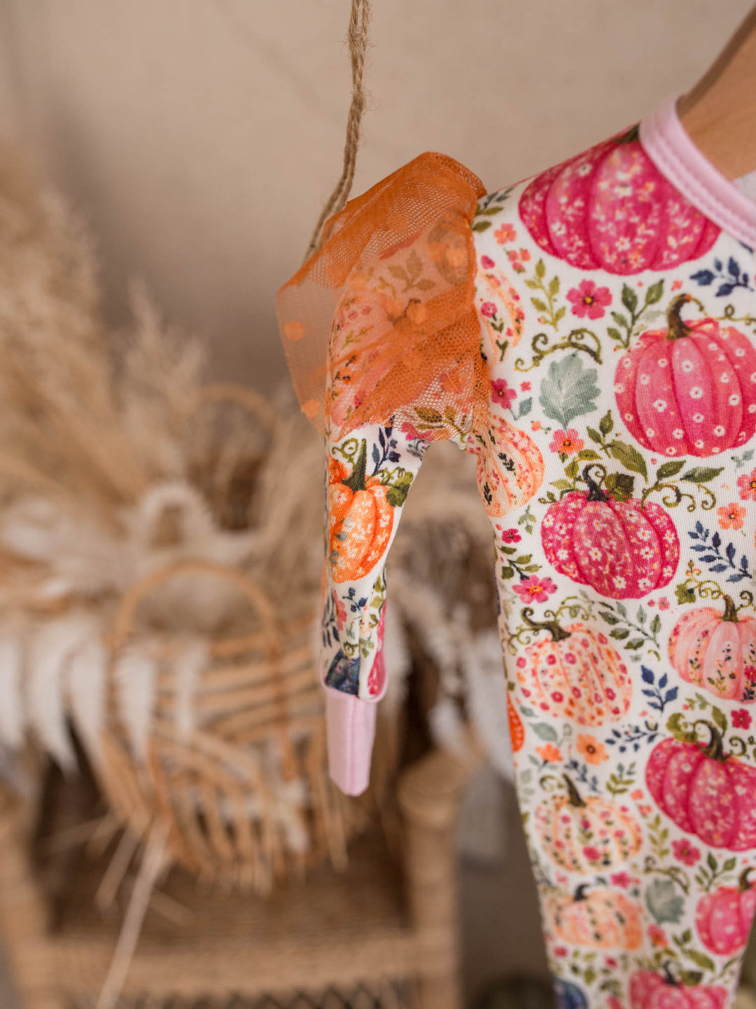 Patch Perfect onesie detail showing rust tulle shoulder frill and pink binding - Before & Ever Kids