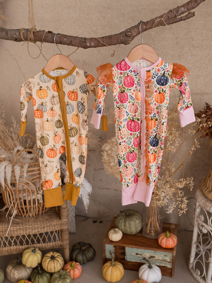 Patch Ready and Patch Perfect matching pumpkin baby onesies hanging together - Before & Ever Kids