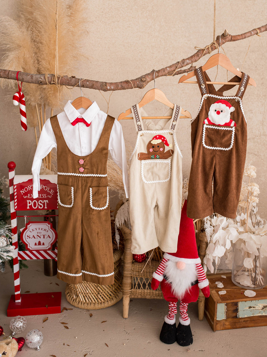 Peekaboo Overall in Santa, chocolate cotton corduroy overall with a Santa face pocket, hanging with the white shirt and a knit romper - Before & Ever Kids