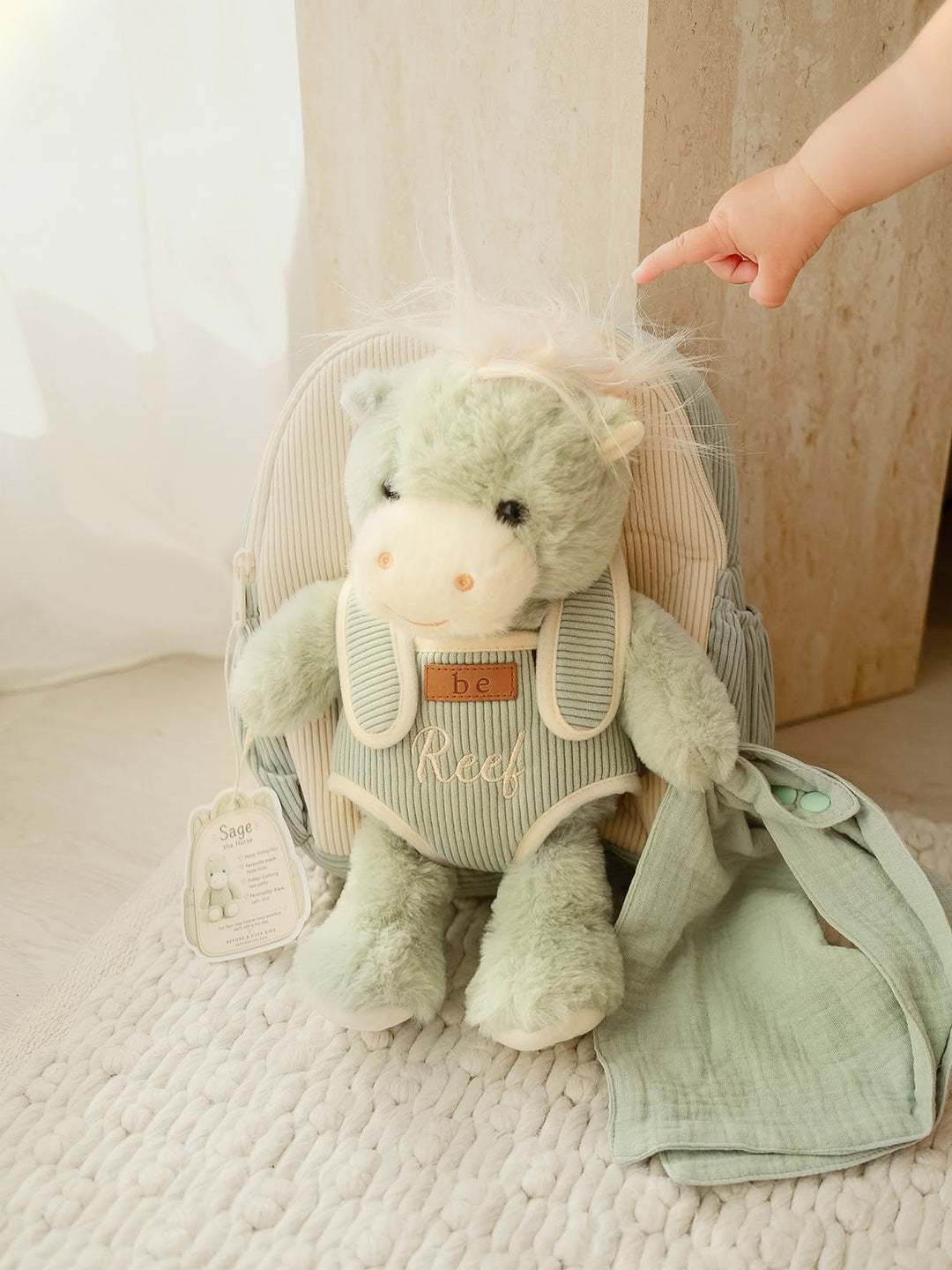 Sage the Horse personalised Little BFF Companion Backpack, sitting on the rug with a little hand reaching for the horse's mane, embroidered name on the front - Before & Ever Kids