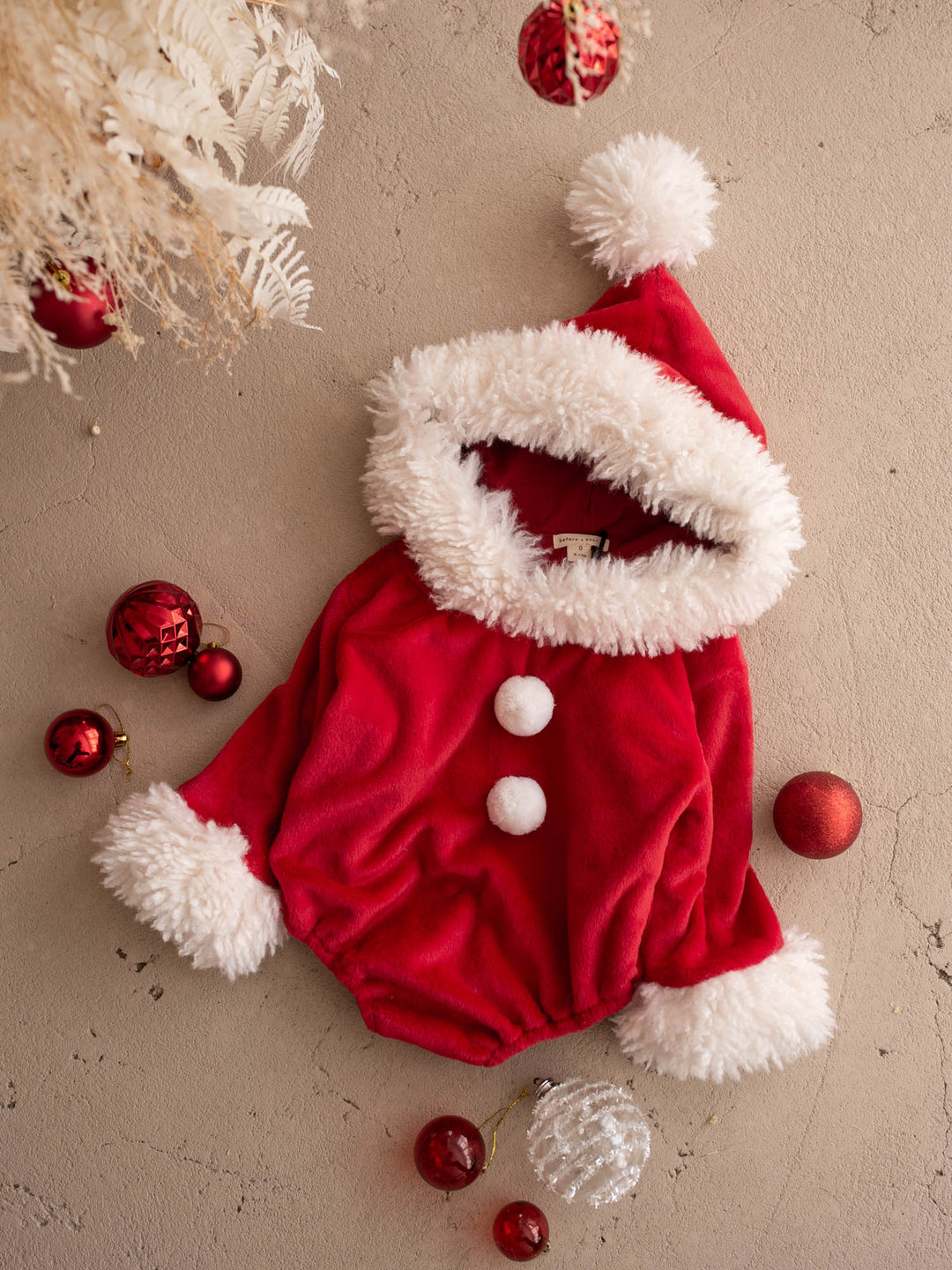 Santa Baby Romper laid flat with red baubles, hood up - Before & Ever Kids