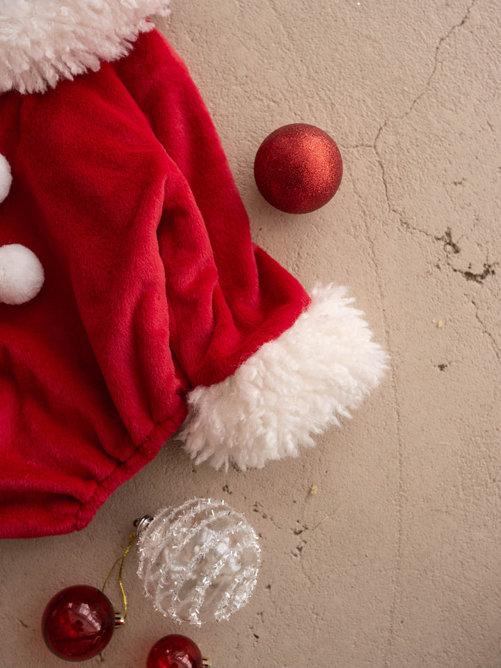 Close up of the pom-poms and fluffy cuff on the Santa Baby Romper - Before & Ever Kids