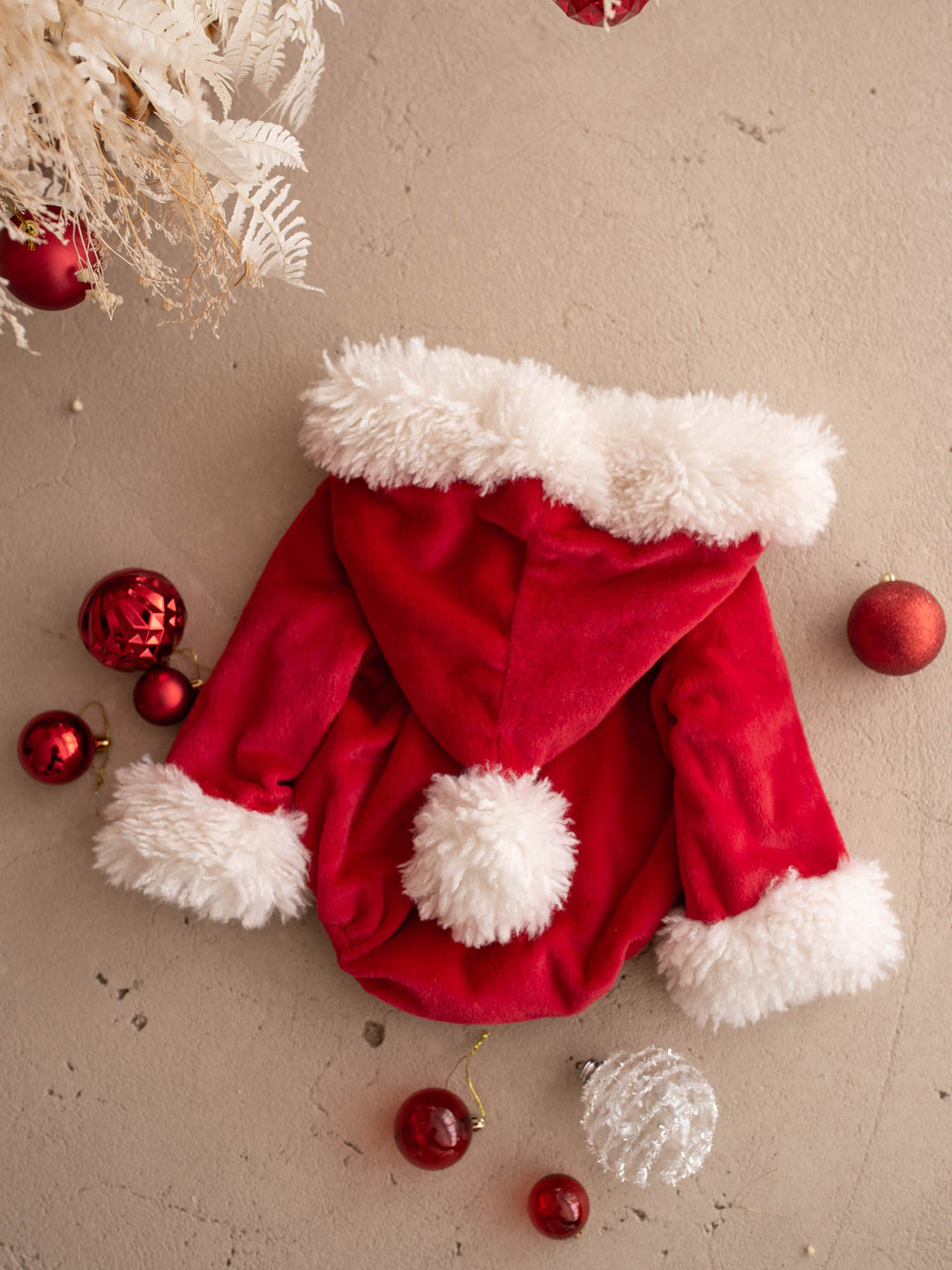 Santa Baby Romper laid flat, back, showing the hood pom-pom - Before & Ever Kids