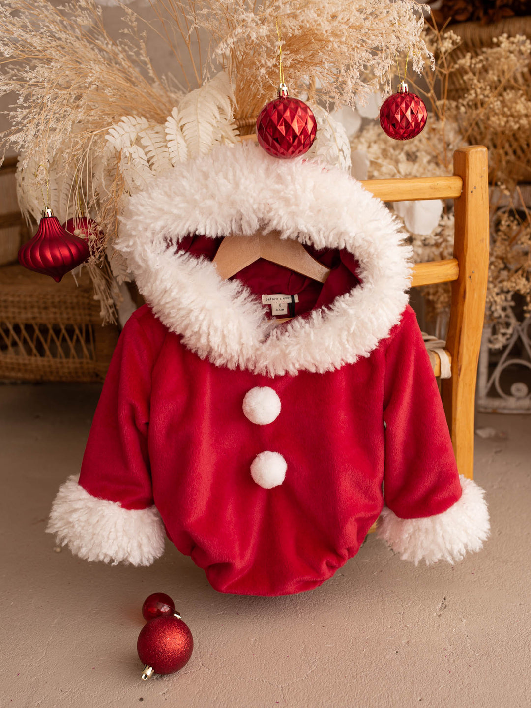 Santa Baby Romper red velvet romper on a wooden chair, hood open - Before & Ever Kids