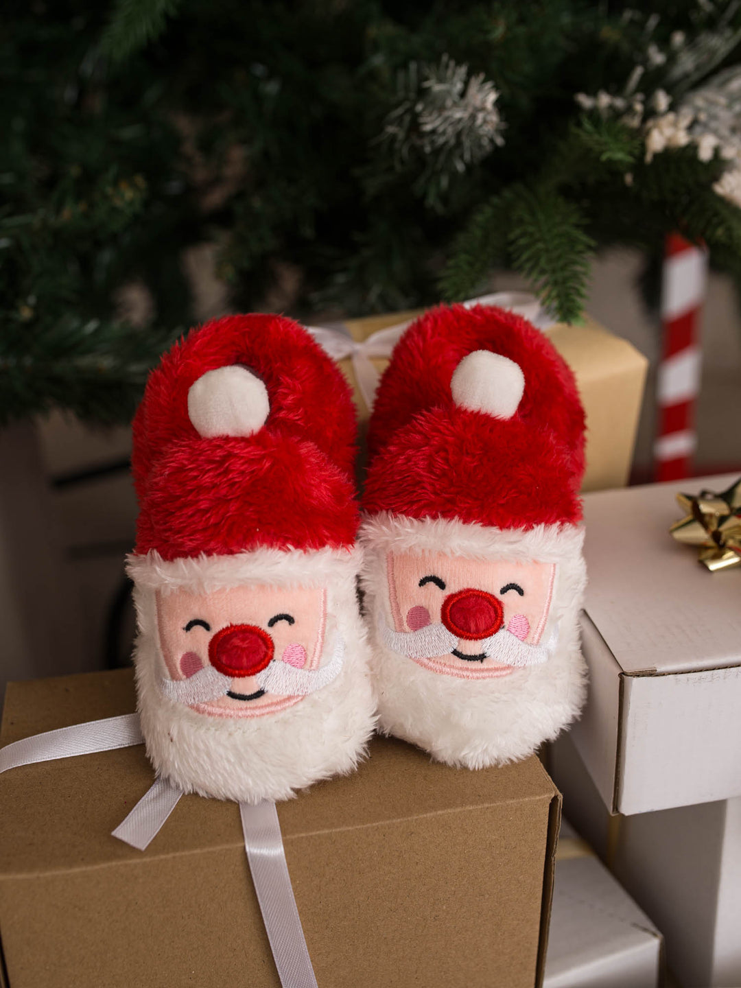 Santa Baby Slippers red fluffy Santa slippers on gift boxes by the tree - Before & Ever Kids