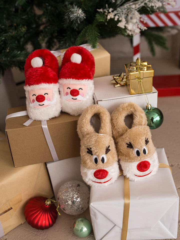Santa Baby Slippers and Baby Rudolph Slippers stacked on gift boxes - Before & Ever Kids