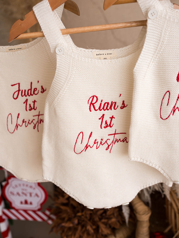 Say My Name Christmas Singlet Romper in milk cotton knit with a personalised name in red, hanging from a branch beside another personalised romper - Before & Ever Kids