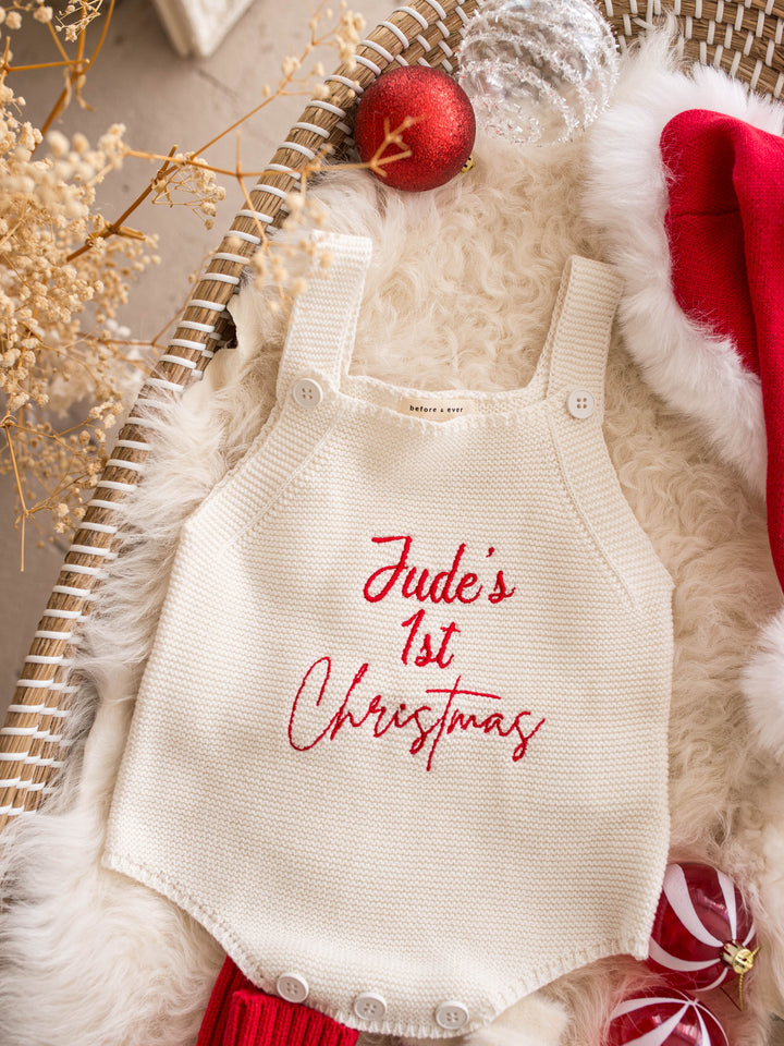Say My Name Christmas Singlet Romper in milk cotton knit with a personalised name in red, on a fur rug with a red Santa hat - Before & Ever Kids