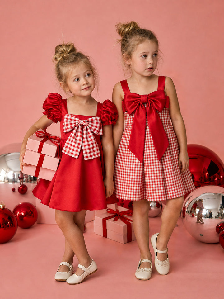 Cherry on Top red satin dress and Sweet as Pie red gingham dress worn together by two girls with Christmas gifts and baubles