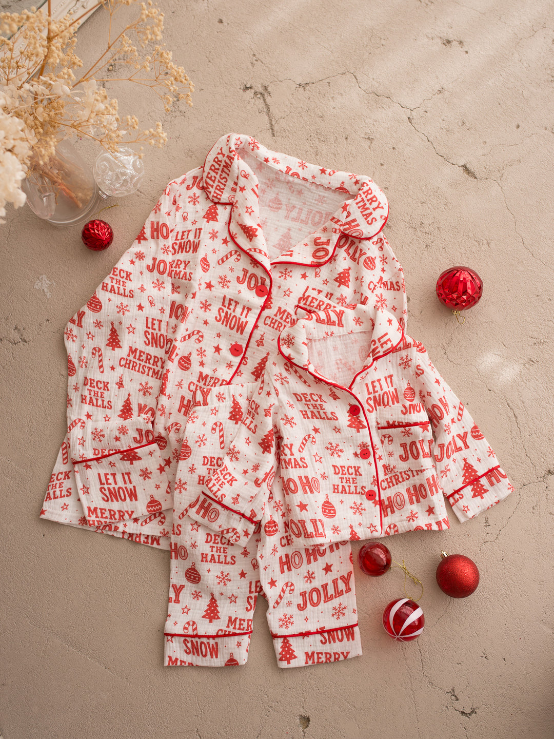 Twas the Night family Christmas pyjamas, white cotton muslin with a red Christmas print, two sizes of the long sleeve sleep shirt and pants laid together - Before & Ever Kids