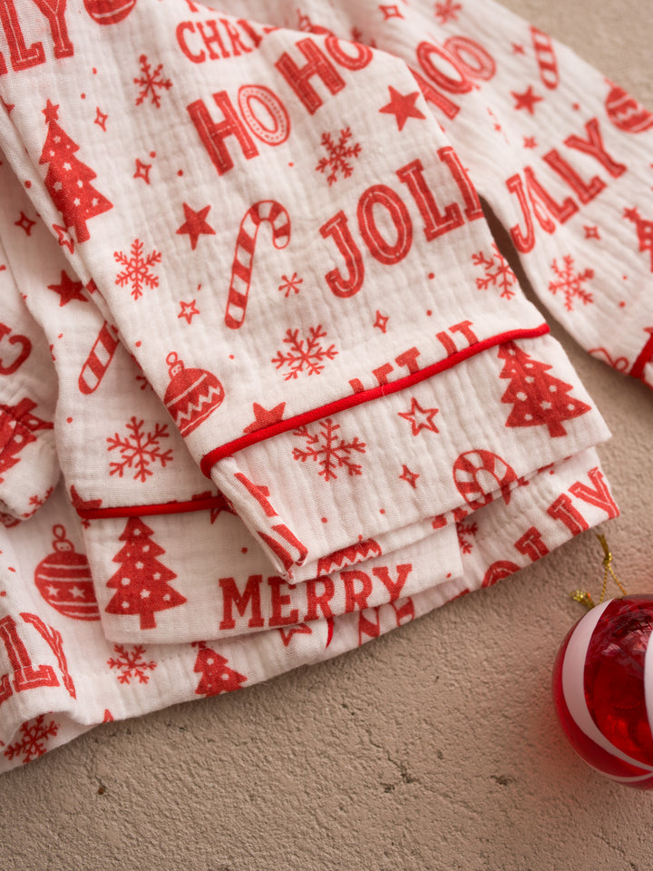 Twas the Night family Christmas pyjamas, white cotton muslin with a red Christmas print, close up of the soft muslin, red piped cuff and Merry print - Before & Ever Kids