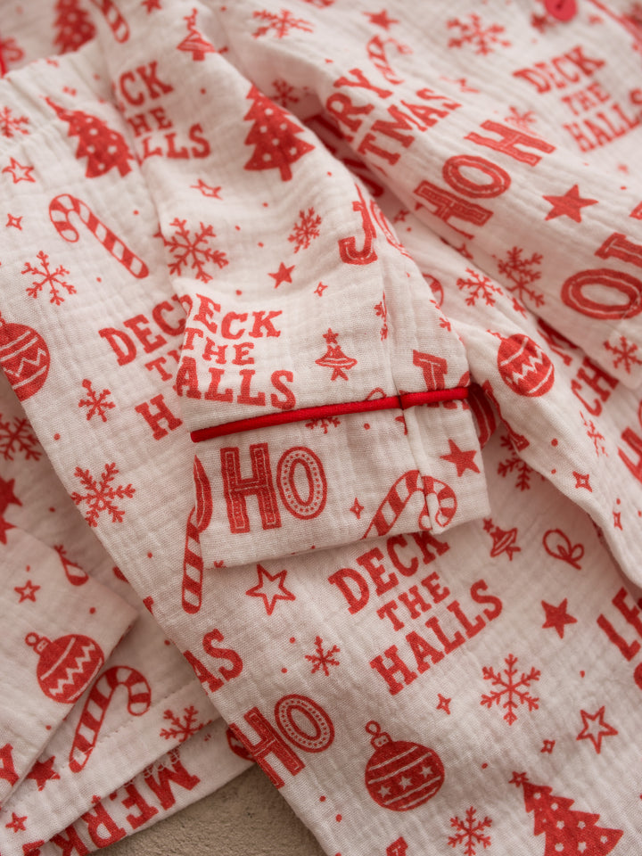 Twas the Night family Christmas pyjamas, white cotton muslin with a red Christmas print, close up of the Deck the Halls print and red piped pocket - Before & Ever Kids