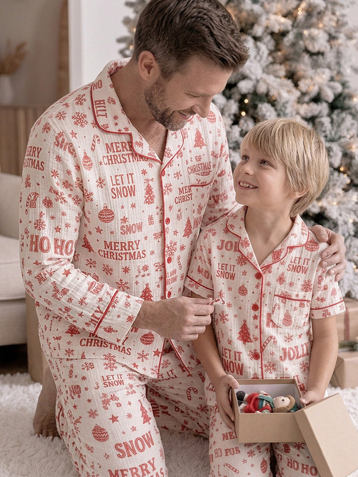 Twas the Night family Christmas pyjamas, white cotton muslin with a red Christmas print, dad in the long sleeve shirt kneeling with the boy over an open present - Before & Ever Kids