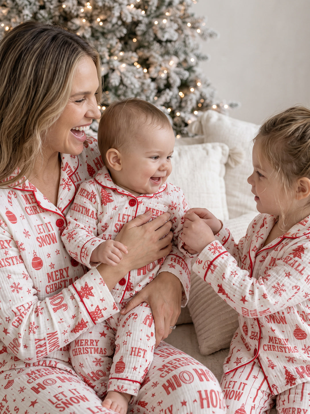 Twas the Night family Christmas pyjamas, white cotton muslin with a red Christmas print, mum holding the baby, both in long sleeves, with the girl - Before & Ever Kids