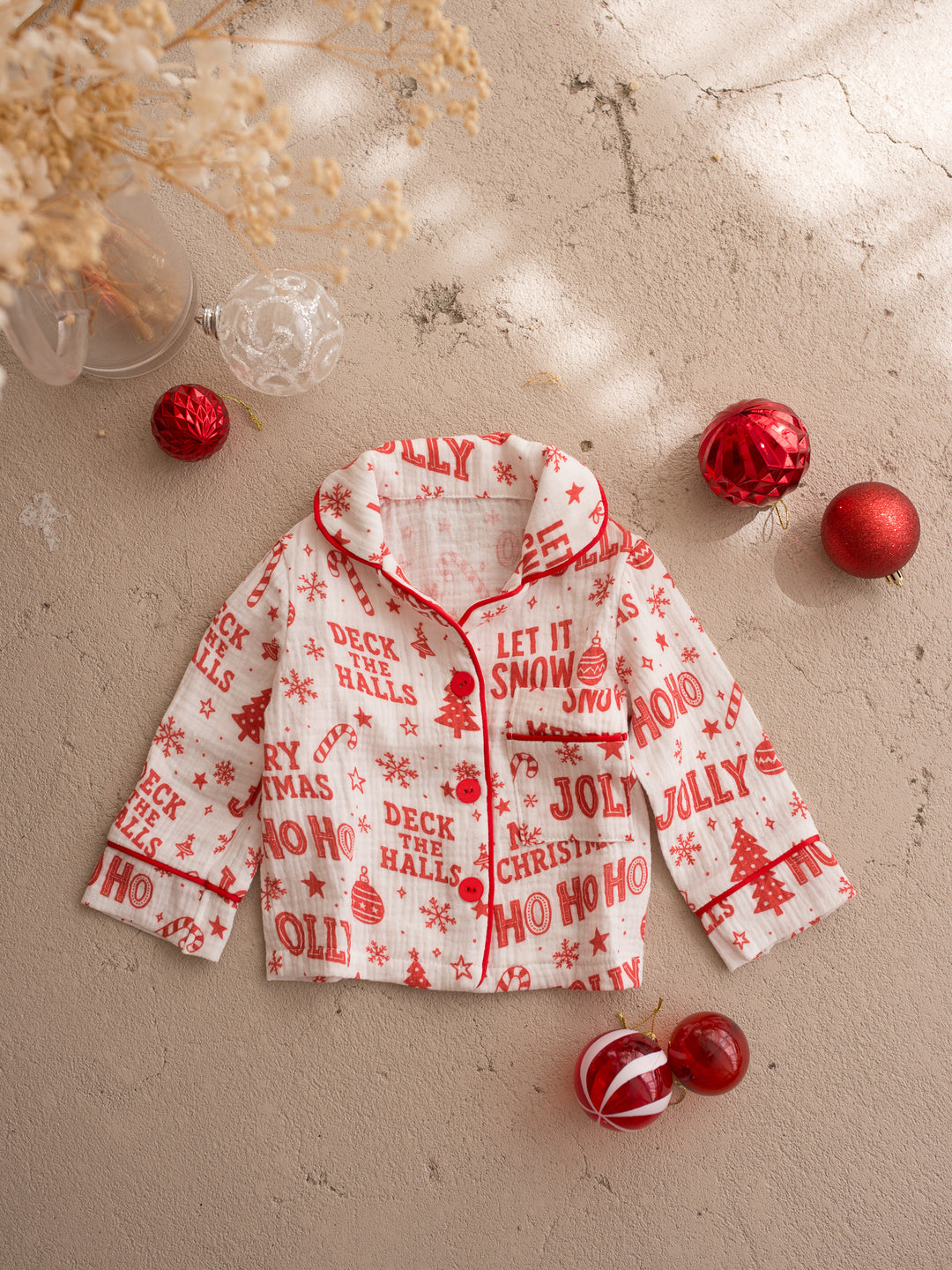 Twas the Night family Christmas pyjamas, white cotton muslin with a red Christmas print, kids long sleeve sleep shirt laid flat, full front, with red piping and Christmas baubles - Before & Ever Kids