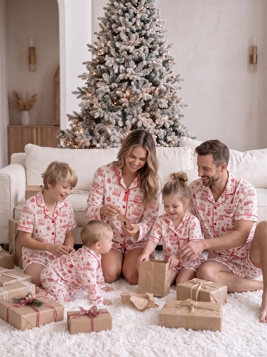 Twas the Night family Christmas pyjamas, white cotton muslin with a red Christmas print, the whole family, mum, dad, boy, girl and baby, by the tree with presents - Before & Ever Kids