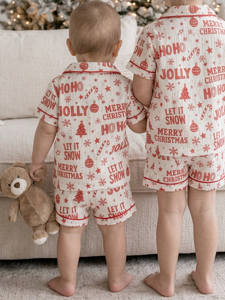 Twas the Night family Christmas pyjamas, white cotton muslin with a red Christmas print, baby and the girl in short sleeves and shorts, back view - Before & Ever Kids