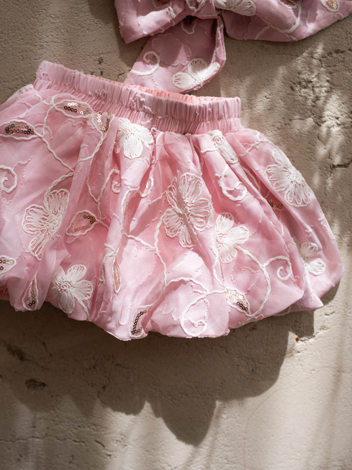 Where Summer Blooms baby pink baby girl set with white floral embroidery, gold sequins, puff sleeves and a bubble-hem skort.